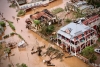 Pessoas caminham em rua inundada da cidade de Buzi, na quarta-feira (20)